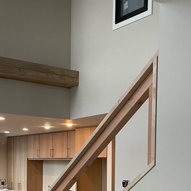 Finished wood stair rail with a floating beam shelf